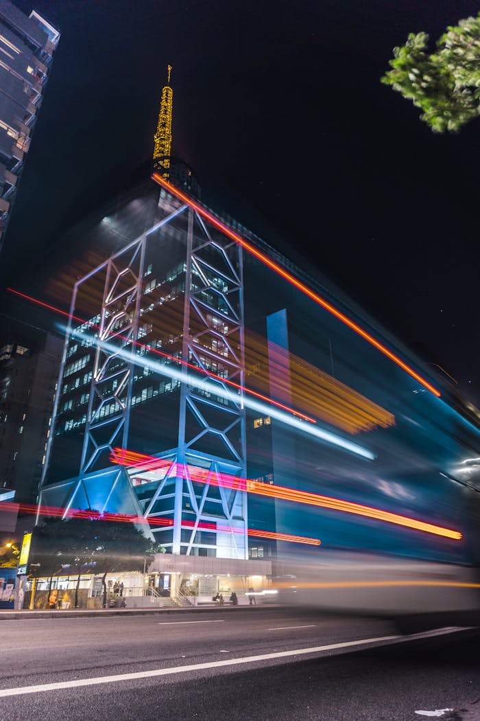 Vibrant nighttime city scene with light streaks highlighting modern architecture.